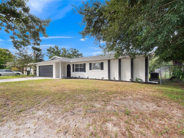 single story home with cooling unit, a front lawn, and a garage