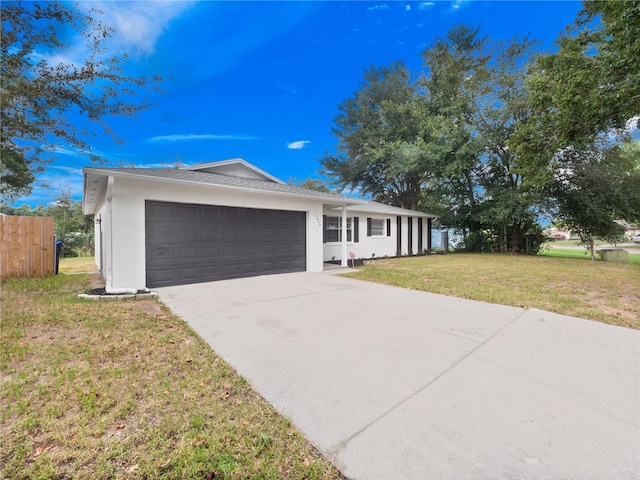 5400 Fox Briar Trl, Orlando, FL 32808 - ranch-style house featuring driveway, stucco siding, a front yard, and an attached garage