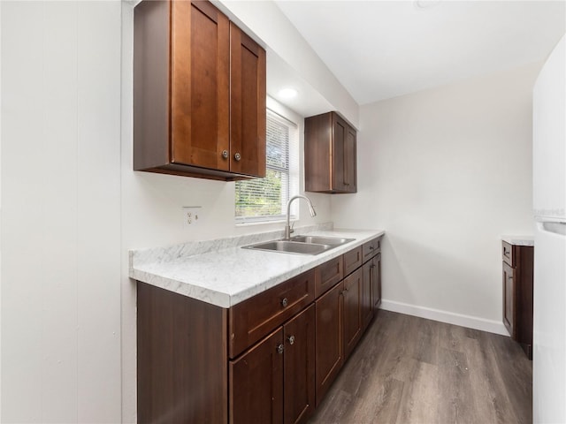 kitchen with wood-type flooring, dark brown cabinetry, and sink