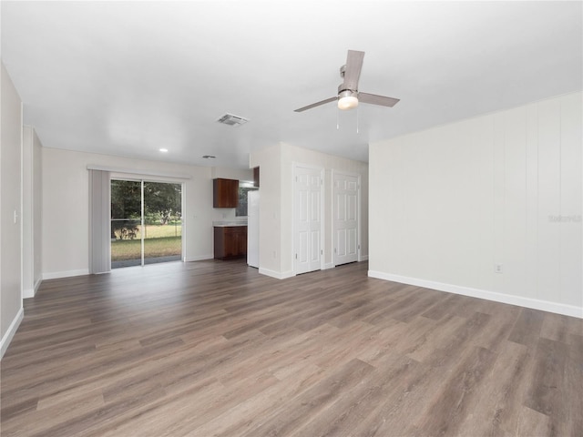 unfurnished living room featuring ceiling fan and light hardwood / wood-style flooring