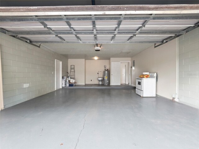 garage featuring water heater, independent washer and dryer, and a garage door opener