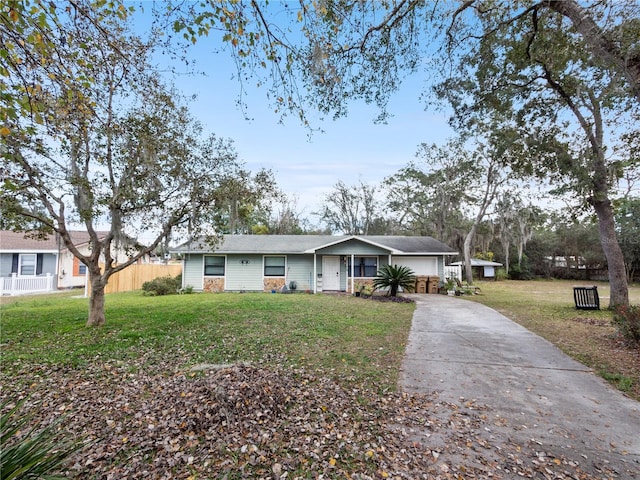 ranch-style home featuring covered porch and a front yard