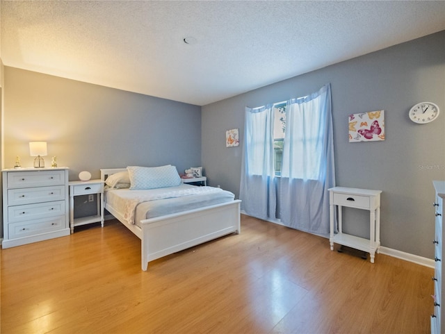 bedroom featuring a textured ceiling and light hardwood / wood-style floors