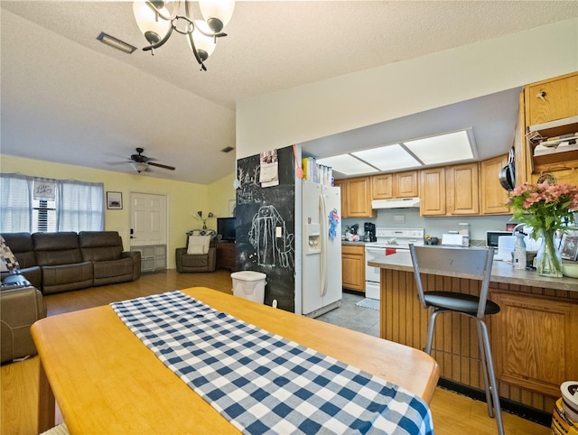 dining space featuring ceiling fan with notable chandelier, vaulted ceiling, light hardwood / wood-style floors, and a textured ceiling