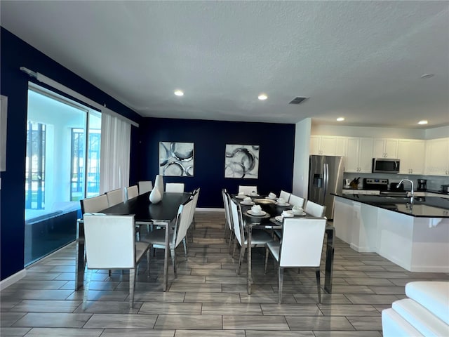 dining room with a textured ceiling and sink