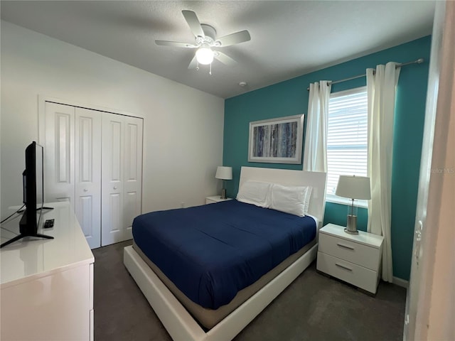 bedroom featuring ceiling fan, a closet, and dark colored carpet