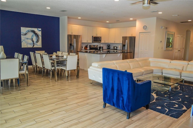 living room with ceiling fan and sink