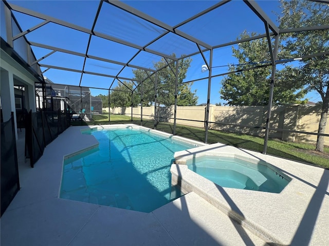 view of swimming pool featuring glass enclosure, an in ground hot tub, and a patio