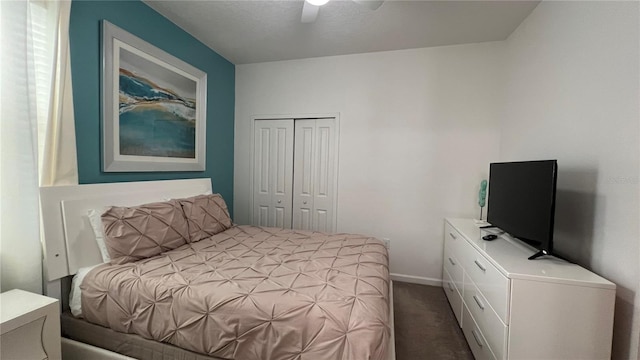 bedroom with ceiling fan, dark carpet, and a closet