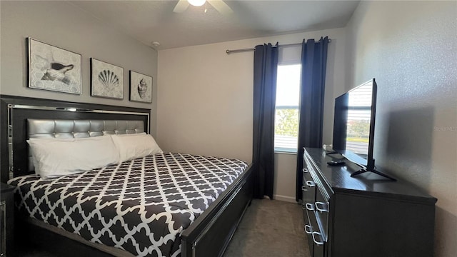 bedroom featuring ceiling fan, multiple windows, and dark colored carpet