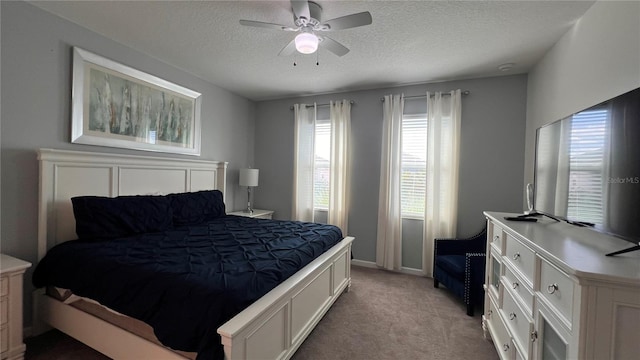 bedroom featuring light carpet, ceiling fan, and a textured ceiling