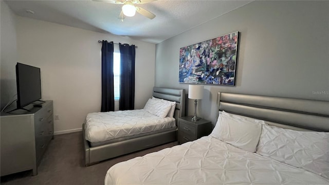 carpeted bedroom with ceiling fan and a textured ceiling