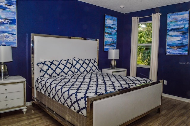 bedroom featuring a textured ceiling and dark hardwood / wood-style floors