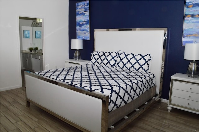 bedroom featuring dark wood-type flooring and ensuite bath