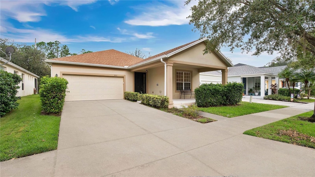 ranch-style home featuring a garage and a front lawn