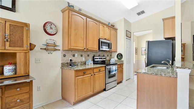 kitchen featuring light stone counters, sink, tasteful backsplash, stainless steel appliances, and vaulted ceiling