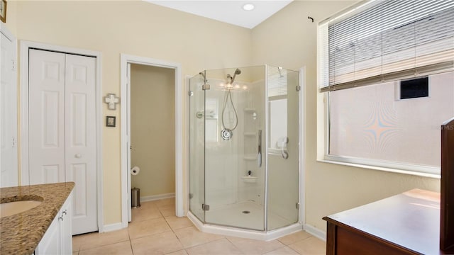 bathroom featuring tile patterned flooring, a shower with door, and vanity