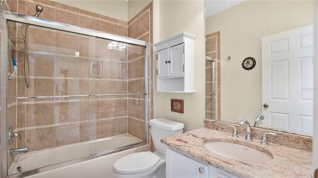 full bathroom featuring combined bath / shower with glass door, vanity, and toilet