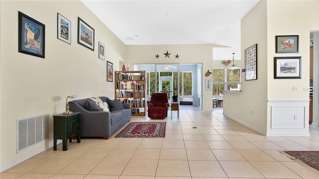 living room with lofted ceiling and light tile patterned floors