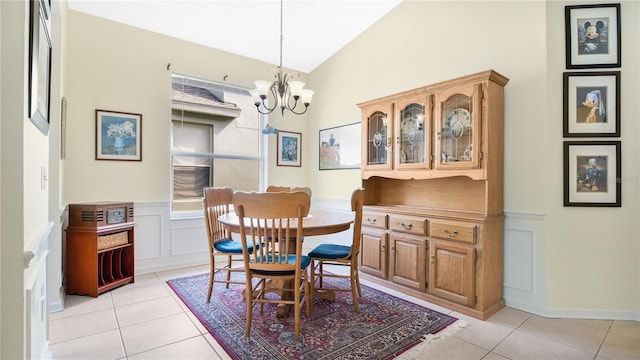 tiled dining room featuring vaulted ceiling and a chandelier