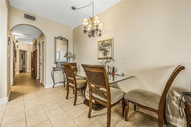 dining area featuring ornamental molding, light tile patterned floors, and a chandelier