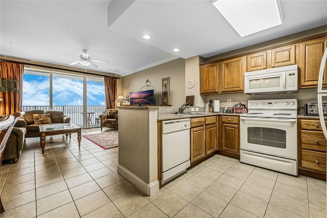 kitchen with ceiling fan, white appliances, crown molding, kitchen peninsula, and light tile patterned floors