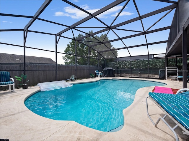 view of swimming pool featuring glass enclosure and a patio