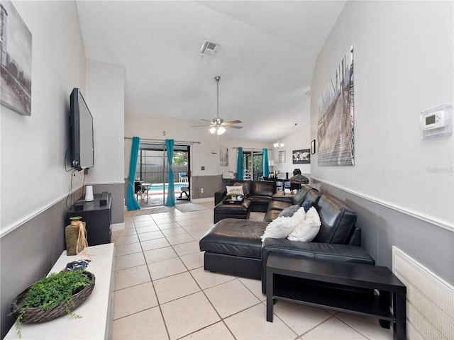 living room featuring ceiling fan, light tile patterned floors, and vaulted ceiling