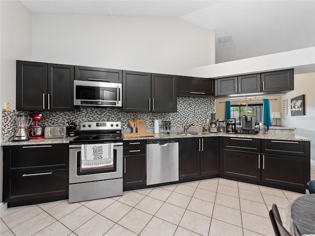 kitchen with light tile patterned floors, sink, tasteful backsplash, high vaulted ceiling, and stainless steel appliances