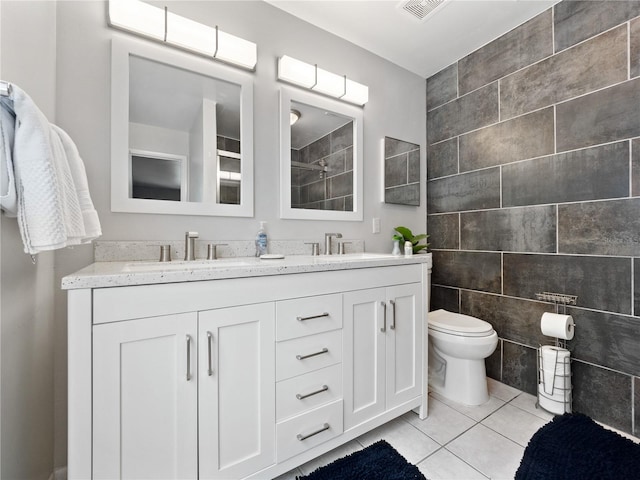 bathroom with tile walls, tile patterned floors, vanity, and toilet