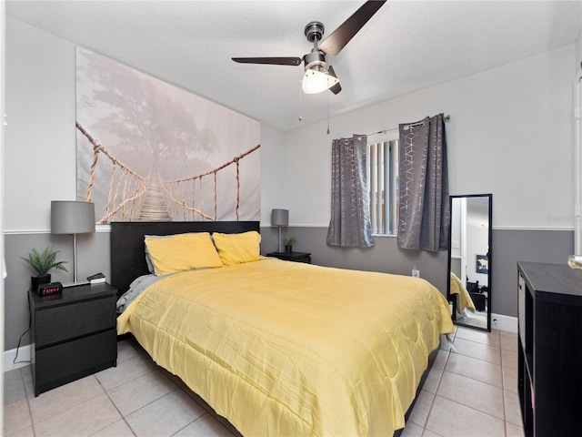 tiled bedroom featuring a textured ceiling and ceiling fan