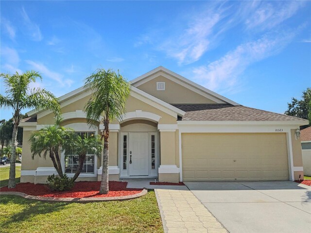 view of front of home with a front yard and a garage