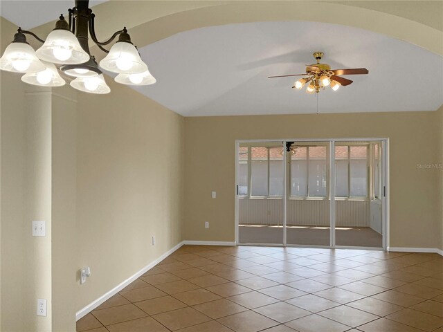 tiled spare room with ceiling fan with notable chandelier and lofted ceiling