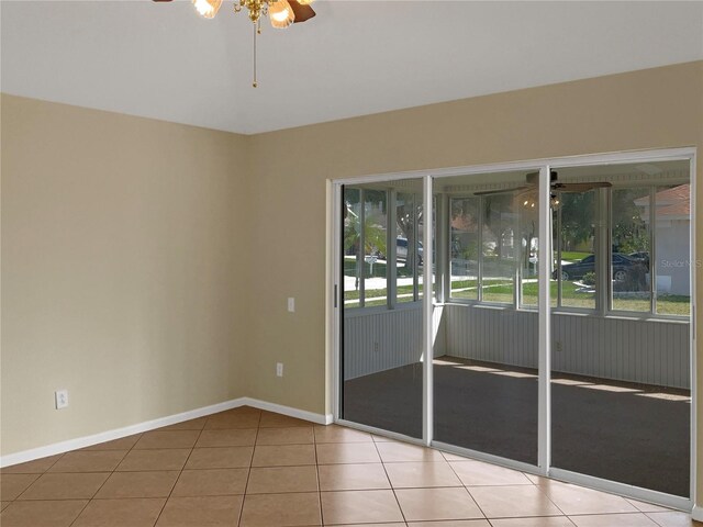 tiled spare room featuring ceiling fan