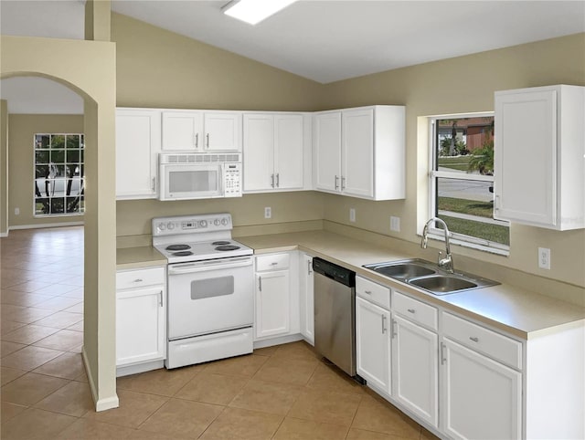 kitchen featuring white cabinets, lofted ceiling, light tile patterned floors, and white appliances