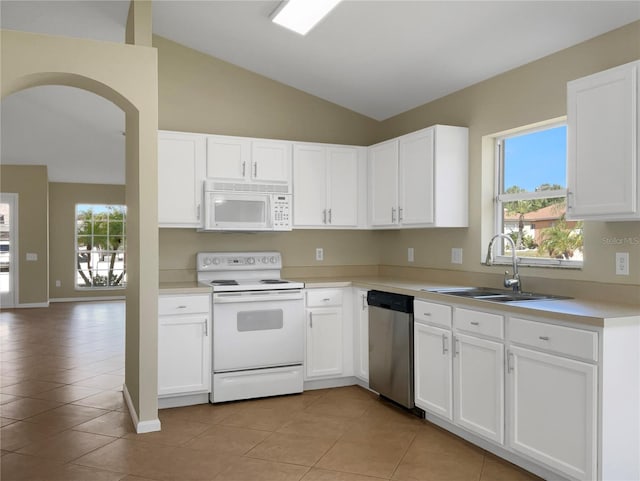 kitchen featuring a healthy amount of sunlight, white appliances, lofted ceiling, and sink