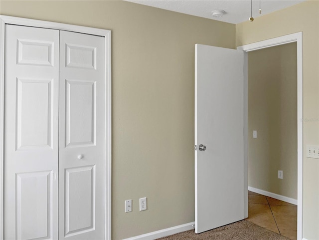 unfurnished bedroom with tile patterned flooring and a closet