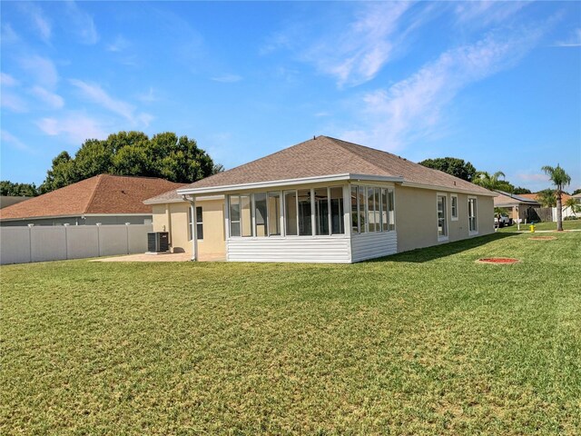 rear view of property with a lawn, a sunroom, and central air condition unit