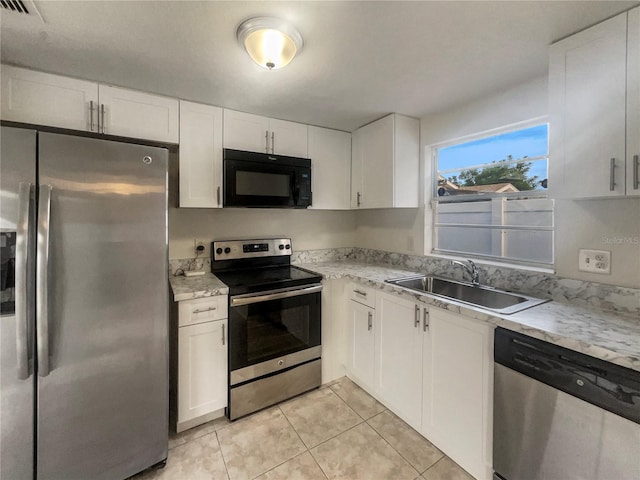 kitchen with light tile patterned floors, white cabinets, stainless steel appliances, and sink