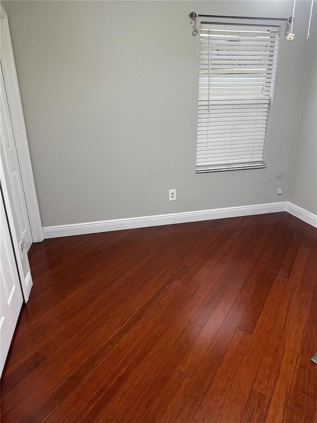 unfurnished room with dark wood-type flooring