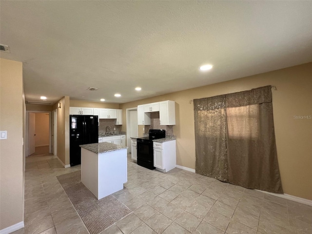 kitchen featuring decorative backsplash, white cabinets, black appliances, a center island, and sink