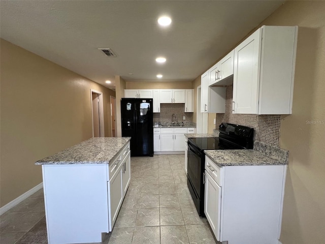 kitchen featuring white cabinetry, backsplash, black appliances, a center island, and sink