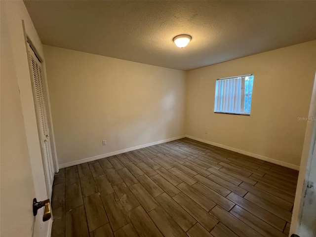 unfurnished bedroom with wood-type flooring, a closet, and a textured ceiling