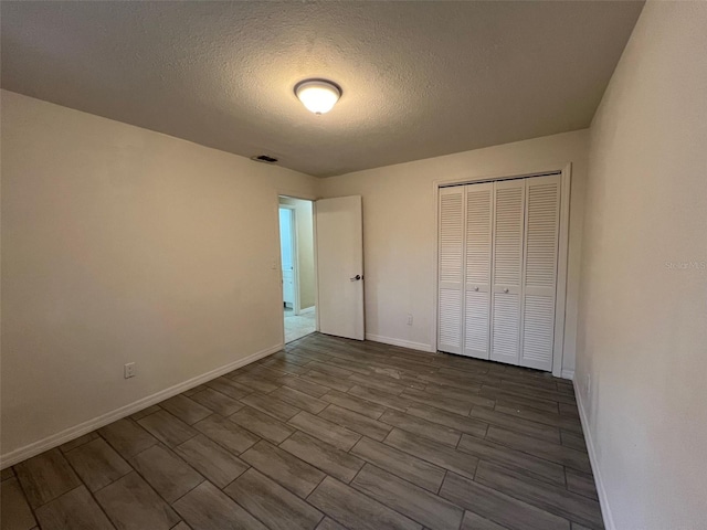 unfurnished bedroom featuring a closet, hardwood / wood-style flooring, and a textured ceiling