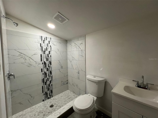 bathroom featuring vanity, toilet, and tiled shower