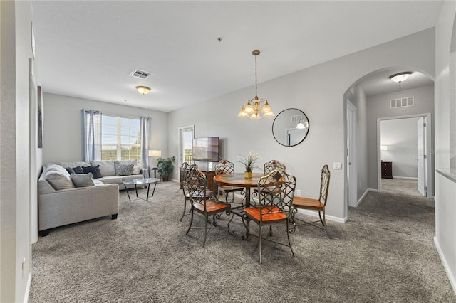 carpeted dining room with a notable chandelier