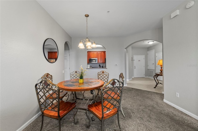 dining space featuring an inviting chandelier and light colored carpet