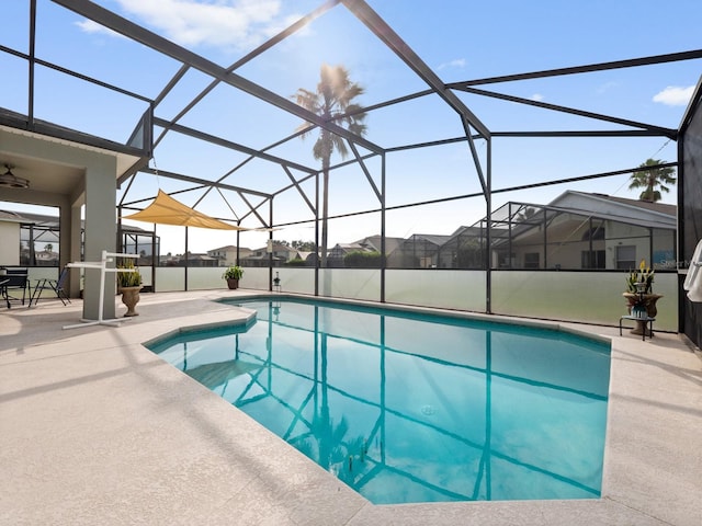 pool with a patio area and glass enclosure