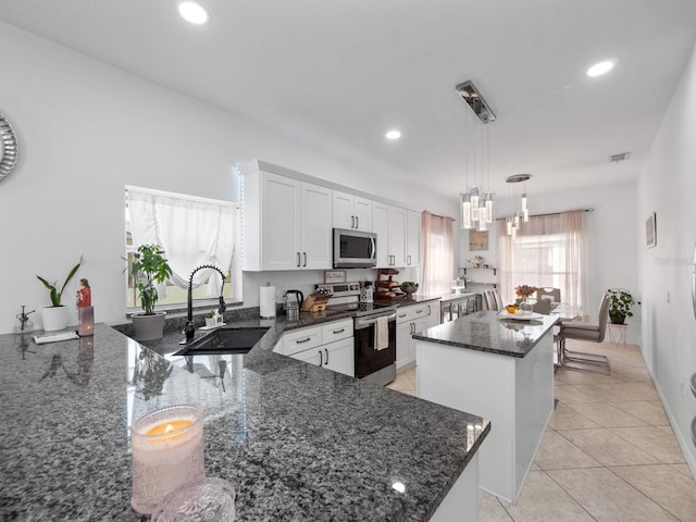 kitchen featuring sink, hanging light fixtures, white cabinets, a kitchen island, and appliances with stainless steel finishes