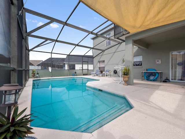 view of swimming pool featuring a patio area and a lanai